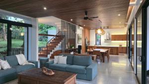 a living room with a blue couch and a table at Maxwell Villa Bali in Tabanan