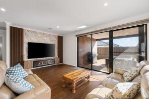 a living room with two couches and a tv at The Island Nirvana in Wimbledon Heights