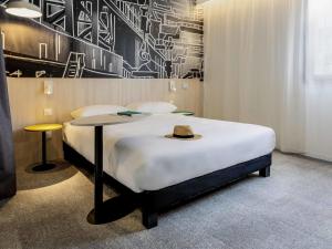 une chambre avec un lit avec un chapeau dessus dans l'établissement ibis Styles Limoges Centre, à Limoges 129 autres photos