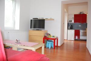 ein Wohnzimmer mit einem Tisch und einem TV sowie eine Küche in der Unterkunft Apartmán Jeseník in Jeseník