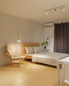 a bedroom with two beds and a chair and a table at Siesta Spaces Boracay in Boracay