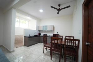 a kitchen with a table and chairs and a ceiling fan at Nandan Enclave 2BHK & 3BHK Family Apartments in Mysore Parking & Kitchen in Mysore