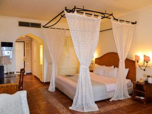 ein Schlafzimmer mit einem Bett mit weißen Vorhängen in der Unterkunft Stanza Luna, Domina Coral Bay, Prestige hotel in Sharm El Sheikh