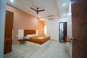 a bedroom with a bed and a ceiling fan at Nandan Enclave in Mysore