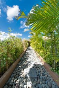 a stone path through a garden with palm trees at Villa Kinaree Estate in Seminyak