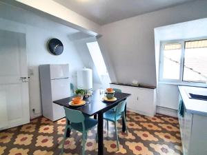 a kitchen with a table and chairs and a refrigerator at Charme et confort au coeur de Mulhouse - Dolce Vita in Mulhouse