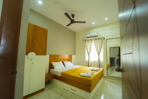 a bedroom with a bed and a ceiling fan at Nandan Enclave in Mysore
