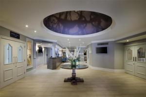 a hallway with a vase of flowers on a table at DoubleTree by Hilton St. Anne's Manor in Bracknell +90 photos
