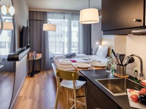 Una cocina con un fregadero y una mesa en una habitación. en Adagio Access Stuttgart Airport Messe, en Leinfelden-Echterdingen