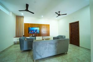 a living room with a couch and a tv at Nandan Enclave in Mysore