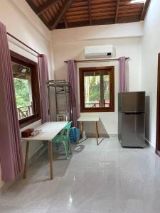 a living room with a table and a refrigerator at Villa Kep Sea & Mountains in Phumĭ Ŏng Char
