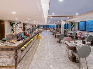 a restaurant with long tables and chairs and tablesktop at Mercure Hefei Huaihe Road in Hefei
