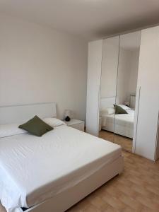 a white bedroom with a bed and a mirror at Casa Martina in Casa Botrona