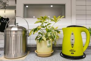 a kitchen counter with two thermos and a plant at wonjong stay 101 김포공항 in Pakkosi