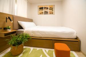 a small bedroom with a bed and a chair at wonjong stay 101 김포공항 in Pakkosi