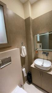 a bathroom with a sink and a mirror at Narrow Gauge Hotel in Bareilly