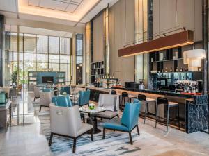 a restaurant with chairs tables and a bar at Pullman Jiaxing Pinghu Excellence in Jiaxing