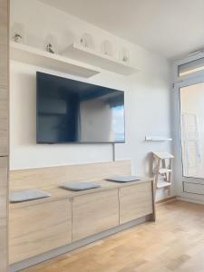 a living room with a large tv on a wall at Kerzen Boutique in Bad Salzuflen