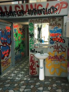 a bathroom with graffiti on the walls and a sink at Sunflower House - Ha Giang Loop Tour in Bản Kin