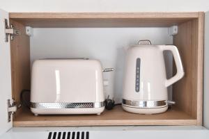 a microwave and a toaster sitting on a shelf at Le Petit Cèpe - Hyper Centre Bergerac in Bergerac