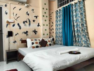 a bedroom with two beds and a wall with birds on it at Quarto inn in Guwahati