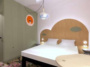 Un dormitorio con una cama grande con cabecero de madera. en ibis Styles Metz Centre, en Metz