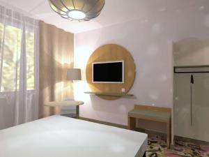 Un dormitorio con una cama y un televisor en la pared. en ibis Styles Metz Centre, en Metz 4 fotos más