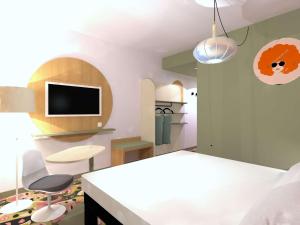 Habitación con mesa, 2 sillas y TV. en ibis Styles Metz Centre, en Metz