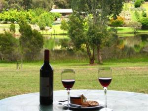 a bottle of wine and two glasses on a table at Pemberton Lake View Chalets in Pemberton