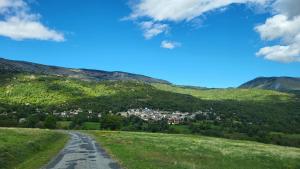 een weg in de bergen met een stad in de verte bij L'Orri in Dorres