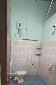 a bathroom with a toilet and a camera on the wall at Nature Nest Rooms in Gokarna