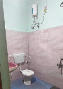 a bathroom with a toilet and a sink at Nature Nest Rooms in Gokarna