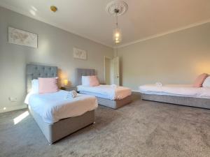 a bedroom with two beds and a couch in it at Ealing Hight's-underground walking direct to Heathrow -shops in Ealing +15 photos
