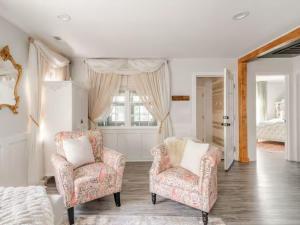 a living room with two chairs and a bed at Venetian Beds, Outdoor Barrel Sauna, Hot tub, Cold Plunge in Charlotte