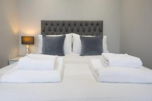 ein Schlafzimmer mit einem weißen Bett mit zwei weißen Kissen in der Unterkunft Parking Space, Doors onto Garden-Pet Friendly in Romford