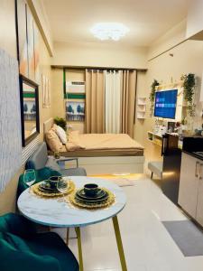 ein Zimmer mit einem Bett und einem Tisch mit Tellern darauf in der Unterkunft SWEET MEMORIES CONDOTEL at THE SYMPHONY TOWERS QC in Manila