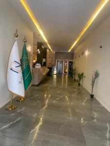 a lobby with a surfboard on a stand in a room at المضياف الذهبية للشقق المخدومة in Abha