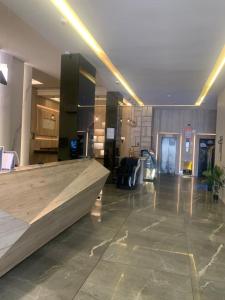 a lobby with a large wooden counter in a building at المضياف الذهبية للشقق المخدومة in Abha