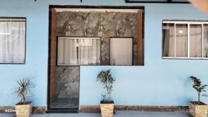 a blue wall with windows and potted plants at Espaço familiar 3 in Vila Velha +12 photos