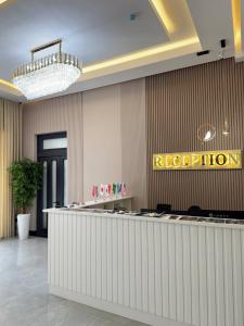 a hotel lobby with a reception counter and a sign at Rich Land Hotel in Samarkand +27 photos