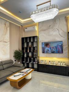 サマルカンドにあるRich Land Hotelのソファとシャンデリアのあるリビングルーム