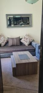 a living room with a couch with a coffee table at appartement forêt diplomatique in Tangier