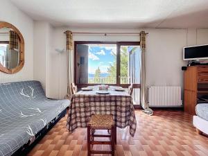 a room with a table and a bed and a window at Le Sciurus - Studio avec terrasse - Parking in Font Romeu Odeillo Via +2 photos