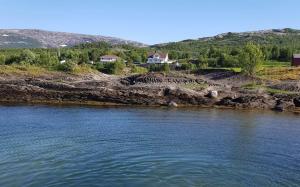 a view of a river with a house in the background at Exclusive villa by the sea, close to Saltstraumen in Bodø +4 photos