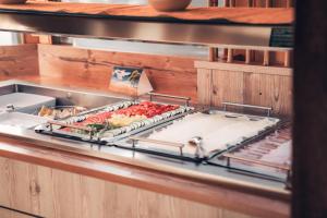 una cocina con varias bandejas de comida en un estante en Hotel Samerhof - Skidepot inklusive, en Tröpolach