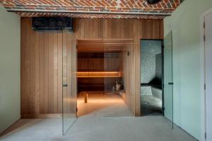 ein Raum mit einer Glastür und einer Bank darin in der Unterkunft Ferme de Pétrieux - Gîte "Le Tilleul" avec piscine et wellness in Tournai