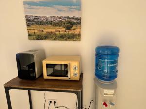 a microwave and a water bottle sitting on a table at Suites Benalup Centro in Benalup Casas Viejas +9 photos