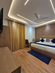 una camera da letto con un letto, una scrivania e una televisione di Hotel The Olive Aero Suite Near Delhi Airport a Nuova Delhi