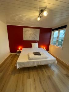 a bedroom with a white bed in a red wall at Modern 7-Bedroom Villa for Large Families & Groups in Rødby