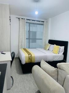 a hotel room with a bed and a couch at Unique by Rose Homes in Nairobi